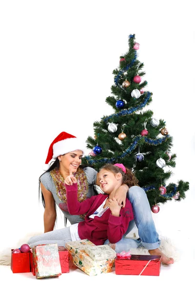 Мать и дочь возле рождественской елки с подарками, изолированные на белой б — стоковое фото