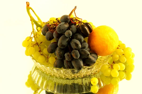 Grapes and a lemon in the glass vase — Stock Photo, Image
