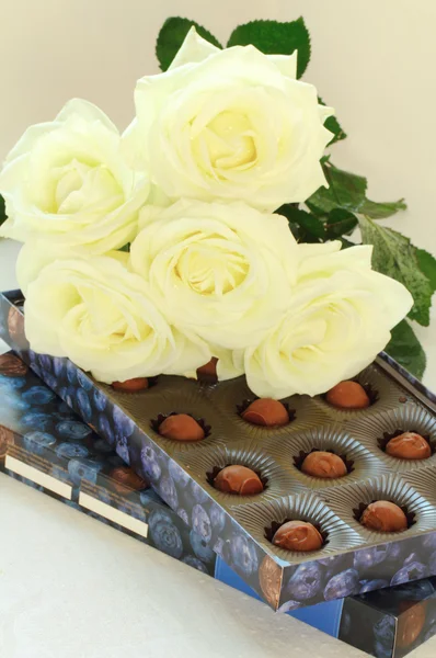 Une boîte de chocolats et de roses blanches — Photo