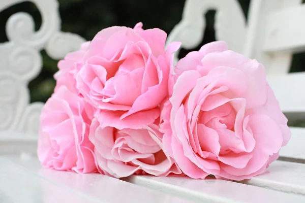 Rózsaszín rózsák, fehér padon — Stock Fotó
