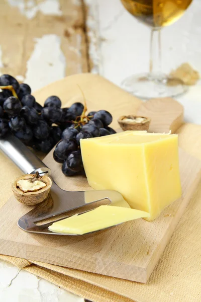 Piatto di formaggio con uva su fondo di legno — Foto Stock