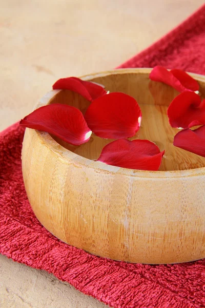 Spa concept met rozenblaadjes en een rode handdoek — Stockfoto