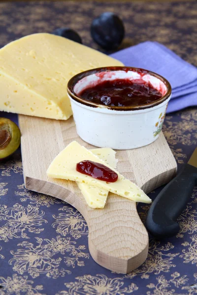 Jar of plum jam and some slice cheese — Stock Photo, Image