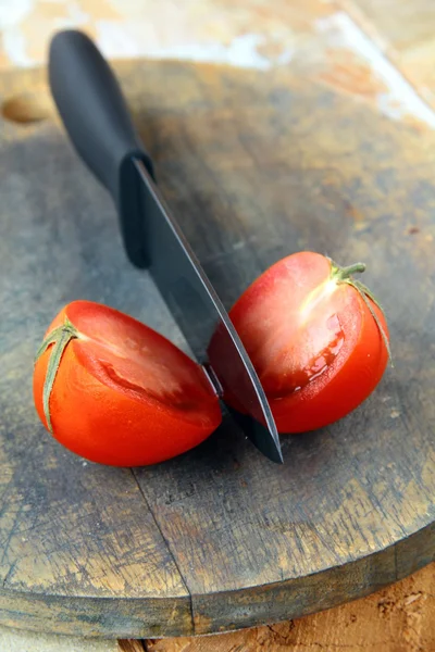 stock image Ceramic knife and tomato on wooden table