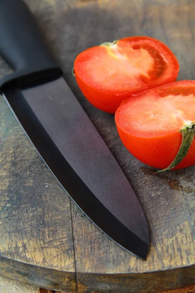 stock image Ceramic knife and tomato on wooden table