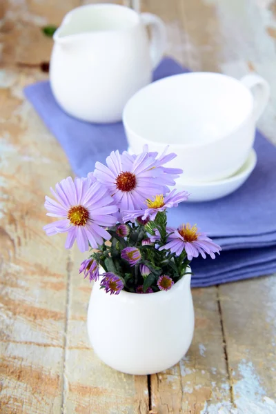 Instelling van de tabel van de lente met lila servet en bloemen — Stockfoto