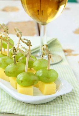 Appetizer canape cheese with white grapes on bamboo skewers clipart