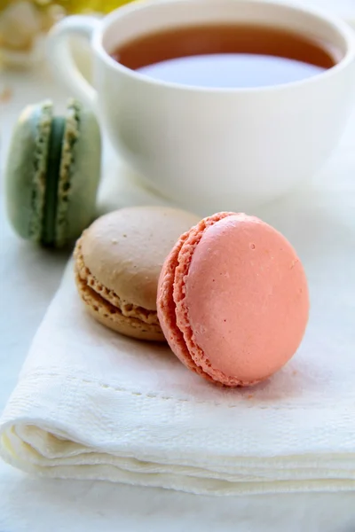 Macarons franceses tradicionais com conjunto de chá no fundo — Fotografia de Stock