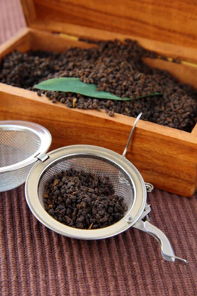 stock image Tea strainer with a fragrant black tea