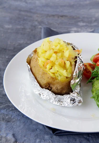 Запеченный картофель со сметаной и сыром, с салатом — стоковое фото