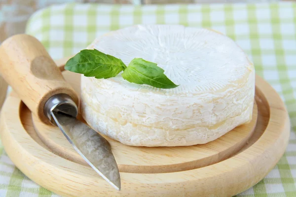 Сыр камамбер на деревянной тарелке и травах — стоковое фото