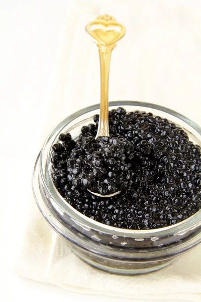 Black caviar in a glass jar on a white background — Stock Photo, Image