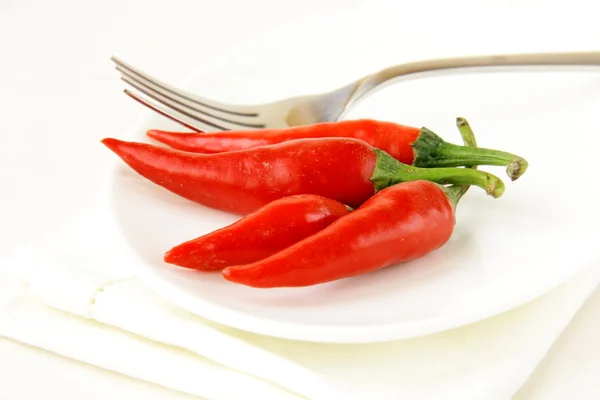 Hot chili peppers na bílé desce — Stock fotografie