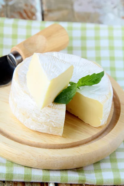 Сыр камамбер на деревянной тарелке и травах — стоковое фото