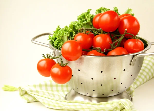 Fresh vegetables in metal colander over white — Stock Photo, Image
