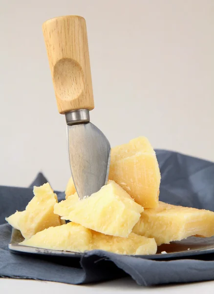 Queso parmesano sobre una mesa de madera con cuchillo —  Fotos de Stock