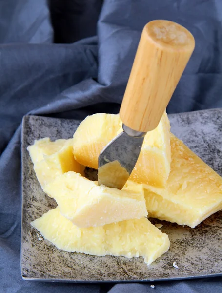 Parmigiano su un tavolo di legno con coltello — Foto Stock