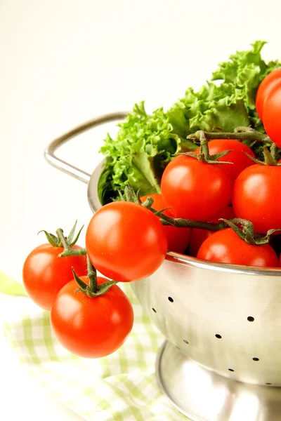 Fresh vegetables in metal colander over white — Stock Photo, Image