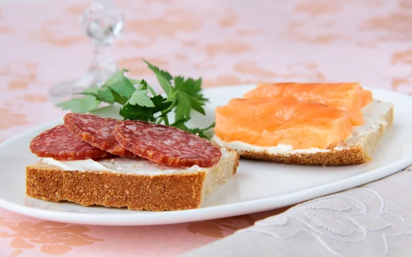 Canape sandwiches with salmon and salami — Stock Photo, Image