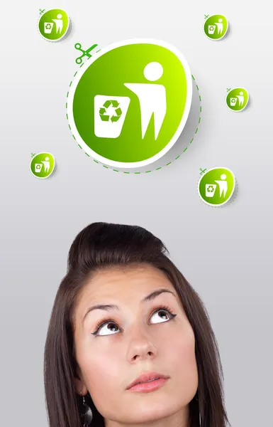 Молодая девушка смотрит на зеленый экологический знак — стоковое фото