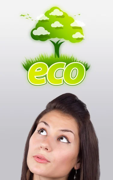 Молода дівчина дивиться на зелений екологічний знак — стокове фото