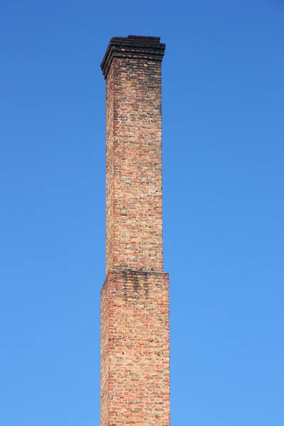 ท่ออิฐสีส้มบนท้องฟ้าสีฟ้า . — ภาพถ่ายสต็อก