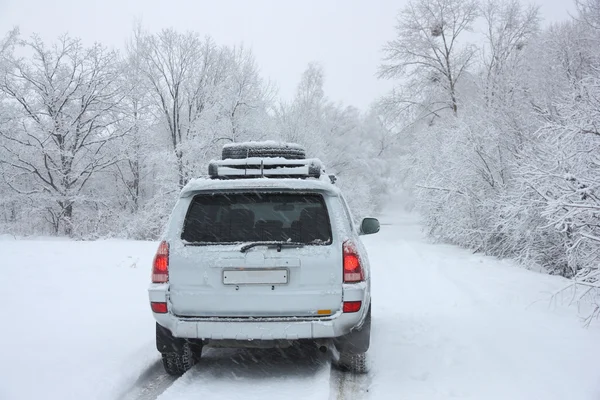 Sněžná zimní cesta za nepoznatelným autem — Stock fotografie