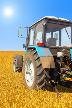 Tractor in a field, agricultural scene in summer clipart