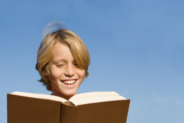 Счастливый ребенок или ребенок читает книгу или Библию — стоковое фото