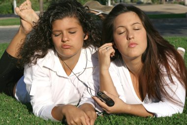 Teens students relaxing on campus listening to music sharing earphones and clipart