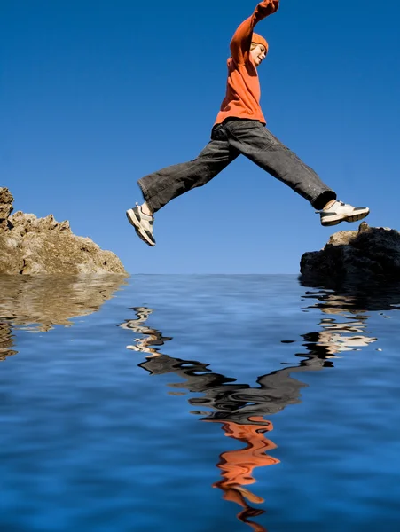 Ajuste sano niño activo saltando rocas en vacaciones — Foto de Stock