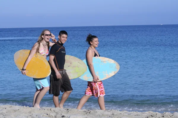 Adolescentes ou jovens em férias na praia de verão com prancha de surf — Fotografia de Stock