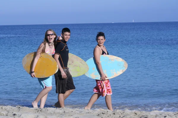 Grupo de niños activos sanos en la playa con tablas de surf —  Fotos de Stock