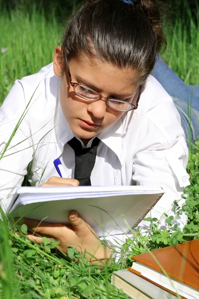 Estudiante escribiendo o estudiando al aire libre en el campus — Foto de Stock