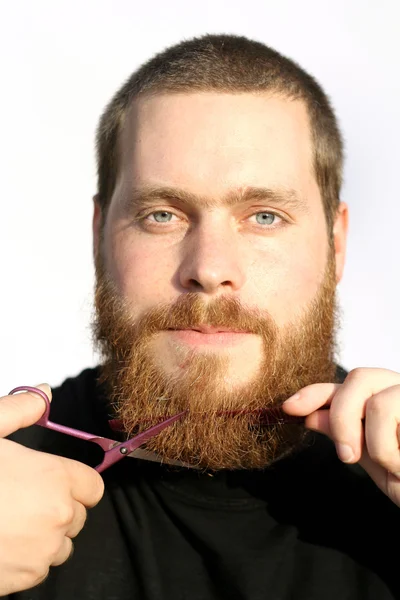 Bearded man trimming or cutting beard with scissors — Stock Photo, Image