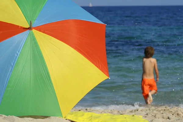 Sommerurlaub am Strand mit farbenfrohem Sonnenschirm — Stockfoto