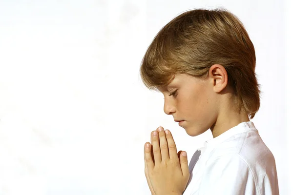 Христианское дитя, молящееся руками, сжатыми в молитве — стоковое фото