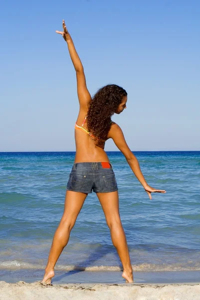 Kumsalda genç kadının yapması germe egzersizleri — Stok fotoğraf