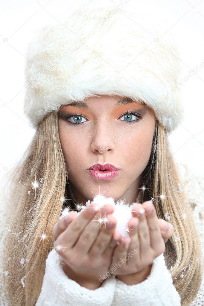 Beautiful girl blowing christmas or new year wishes