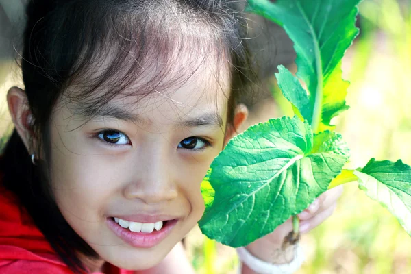 Klein meisje houdt van een groene groente — Stockfoto