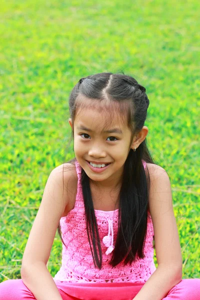 Roztomilá mladá dívka s úsměvem v parku — Stock fotografie
