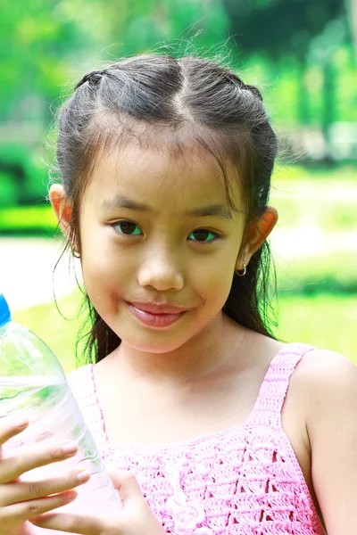 Ung flicka dricksvatten på träning, utomhus — Stockfoto