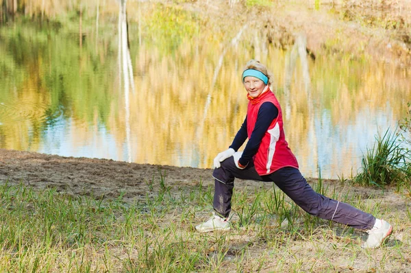 The woman does sports exercises in autumn park — Stock Photo, Image