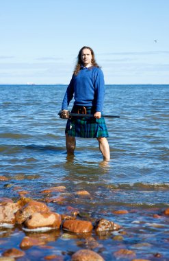 Man in scottish costume in the water clipart