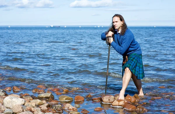Человек в шотландском костюме в воде — стоковое фото