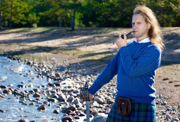 Чоловік в шотландському костюмі з трубкою — стокове фото