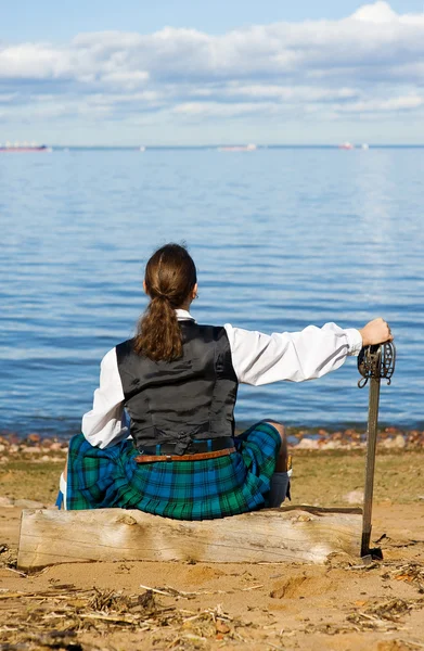 Mann im schottischen Kostüm blickt aufs Meer — Stockfoto