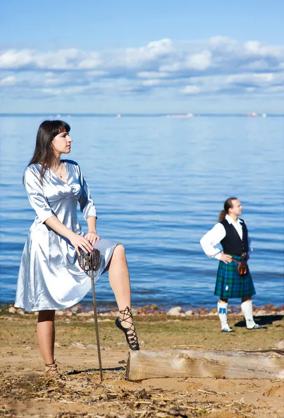 Frau mit Schwert und Mann im schottischen Kostüm — Stockfoto