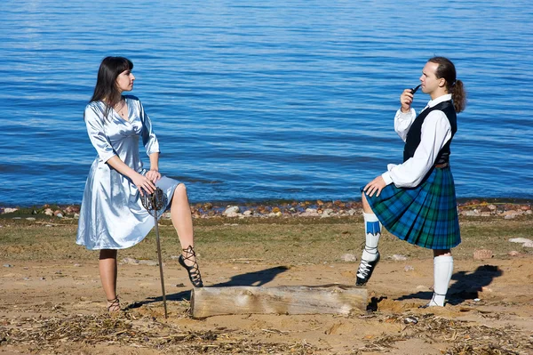 Femme avec épée et homme en costume écossais — Photo