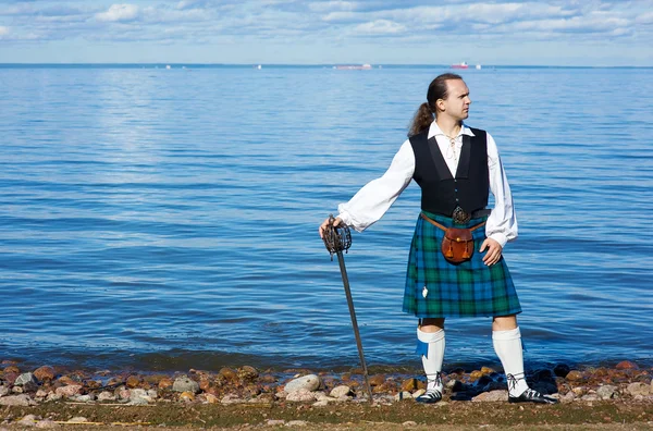 Hombre en traje escocés con espada — Stok fotoğraf